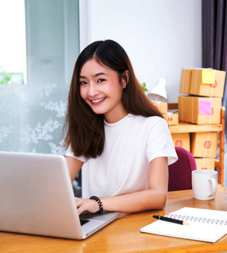 Young asian girl freelancer business private working at home office with laptop, note, coffee, packaging delivery online market on purchase orders to customer.